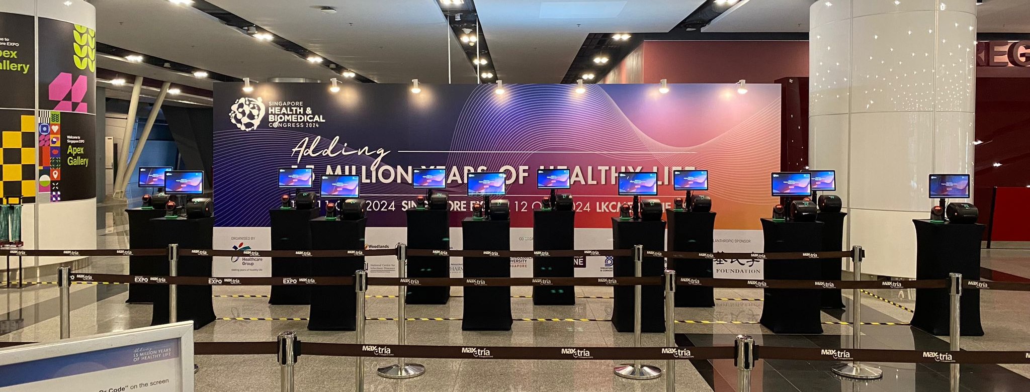 A row of self-service check-in kiosks ready for delegates at a health congress