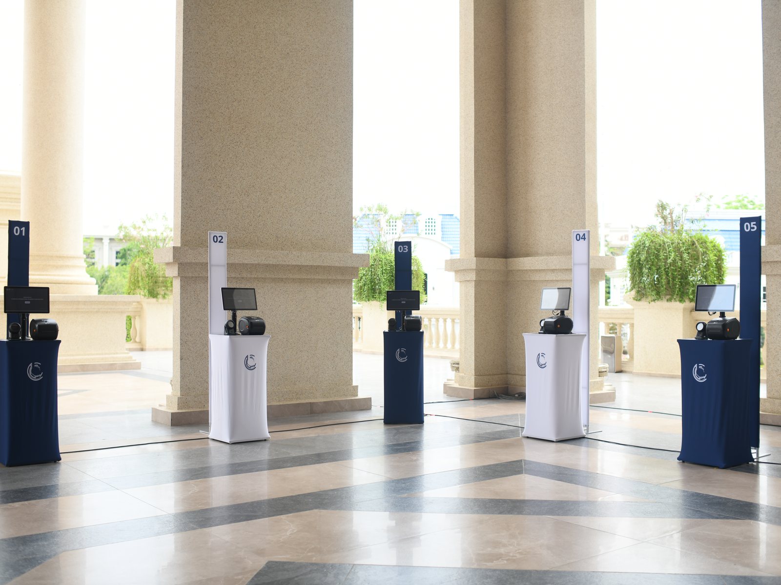 Self-service check-in kiosks lined up under a colonnade, ready for arrivals