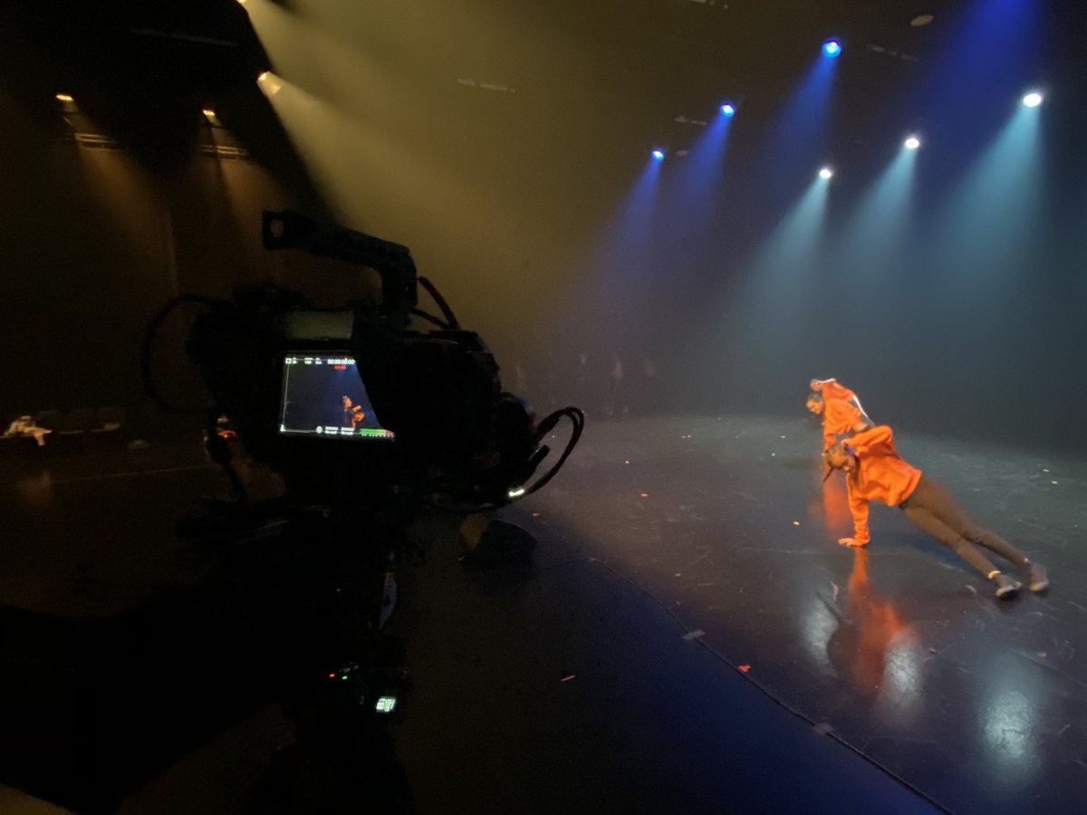 A camera following a dancer on a lit stage