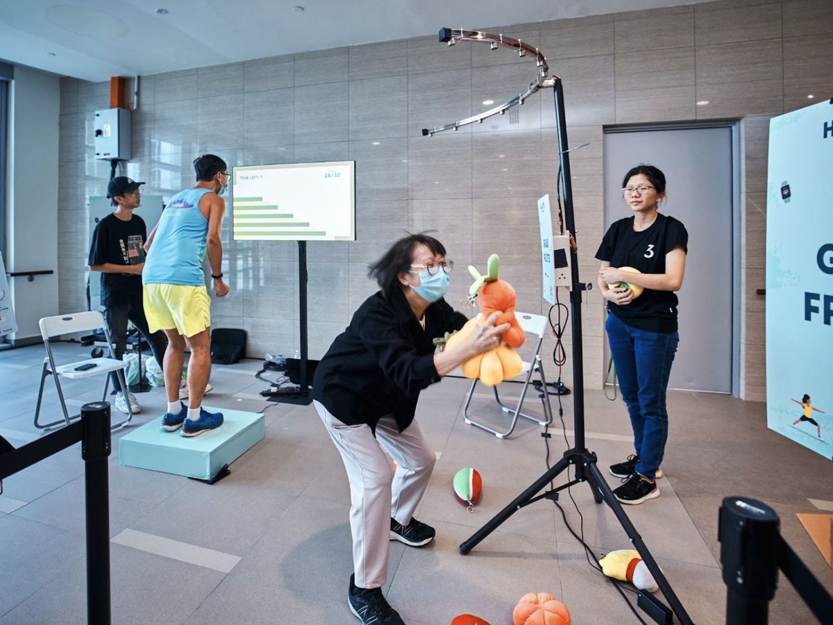 A player racing to catch fruit at a sensor-triggered game station