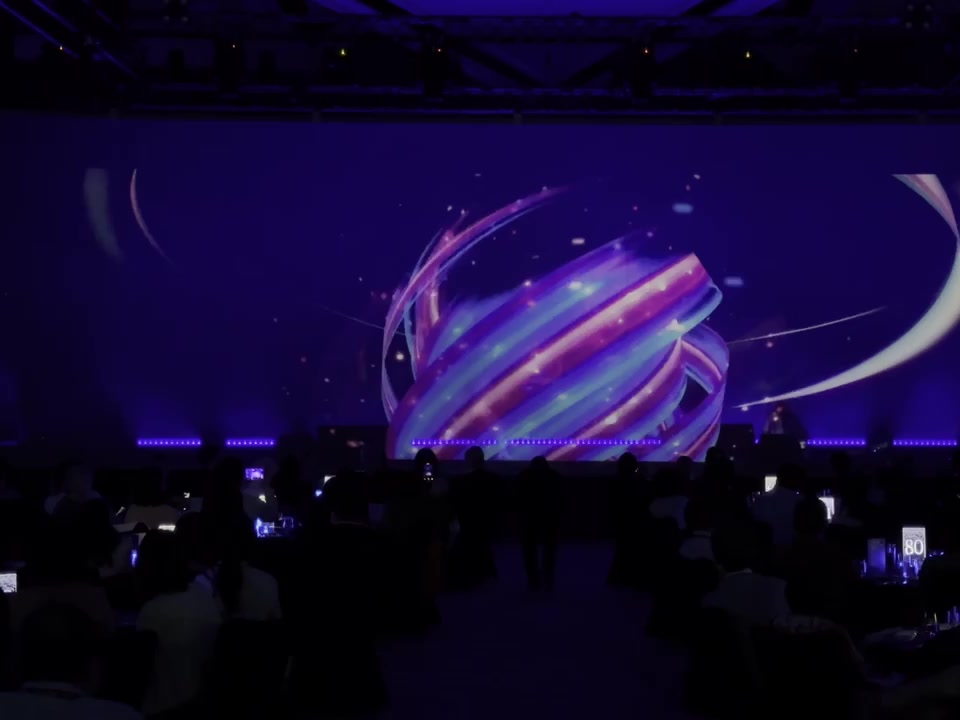 A holographic sphere of light ribbons filling the stage