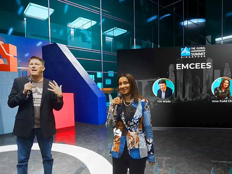Two emcees presenting from a virtual studio set for a hybrid summit