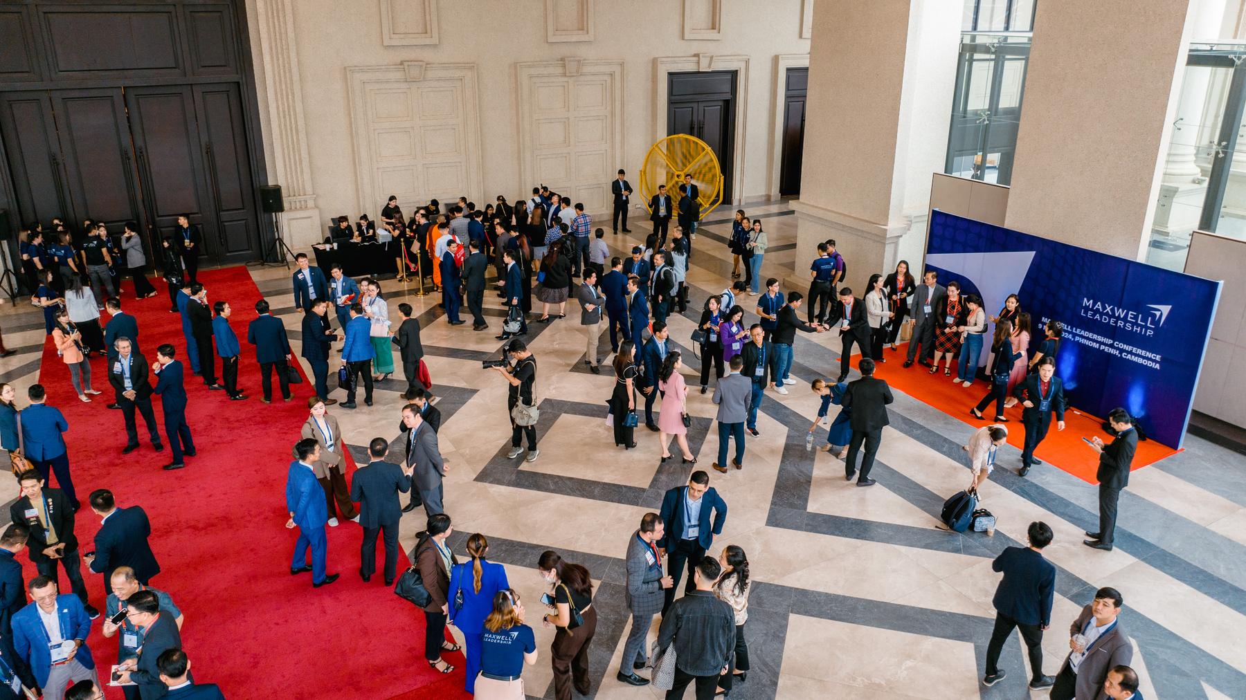 Aerial view of guests arriving along a red carpet at a leadership conference